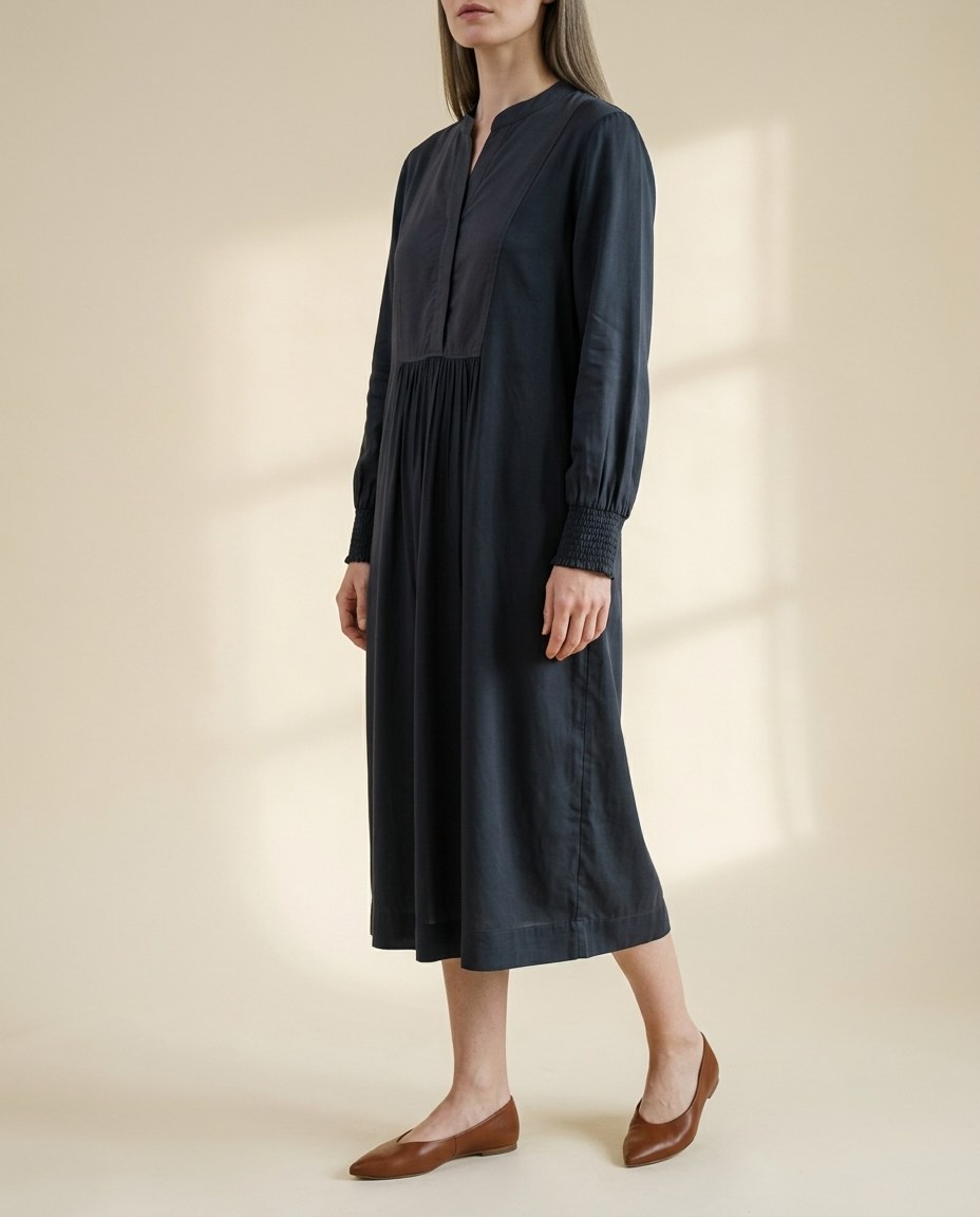 Faceless model in a midnight pleated shirt dress