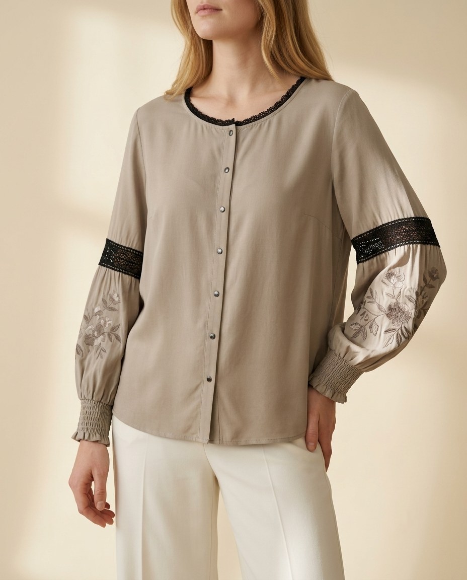 Faceless model in a taupe blouse with embroidered sheer sleeves